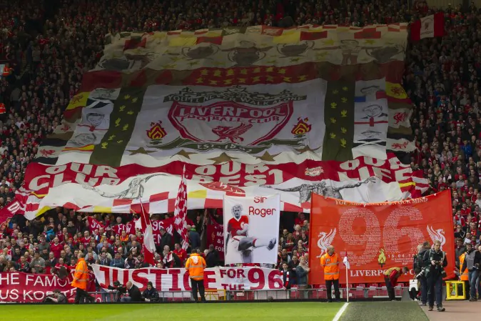 Liverpool supporters hold banners prior to a minute's silence in tribute to the 96 supporters who lost their lives in the Hillsborough disaster of 25 years ago on 15 April 1989, Liverpool, England, Sunday April 13, 2014. (AP Photo/Jon Super)