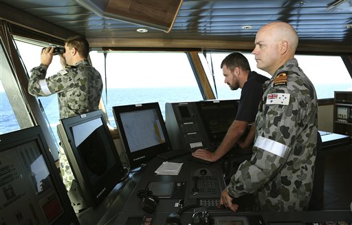 In this April 5, 2014, photo provided by the Australian Defense Force, Commander James Lybrand, right, watches from the bridge with Captain Nick Woods, Master of the ship, left, as they tow a pinger locator behind the Royal Australian Navy ship Ocean Shield in the southern Indian Ocean. Ocean Shield, which is carrying high-tech sound detectors from the U.S. Navy, is investigating a sound it picked up. (AP Photo/Australian Defense Force, Bradley Darvill)