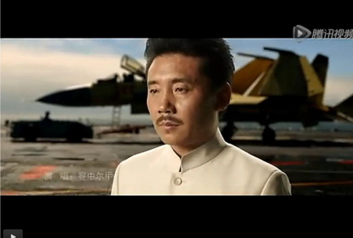 The Tibetan singer Rongzhongerjia stands on an aircraft carrier and sings about the China dream, in a new military propaganda video made public recently. (Screenshot via qq.com)