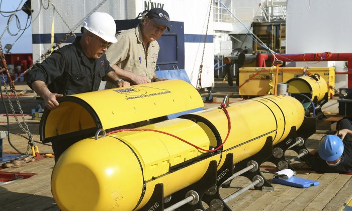 In this Monday, April 14, 2014, photo provided by the Australian Defense Force Phoenix International's Chris Minor, left, and Curt Newport inspect an autonomous underwater vehicle before it is deployed from ADV Ocean Shield in the search of the missing Malaysia Airlines Flight 370 in the southern Indian Ocean. The search area for the missing Malaysian jet has proved too deep for the robotic submarine which was hauled back to the surface of the Indian Ocean less than half way through its first seabed hunt for wreckage and the all-important black boxes, authorities said on Tuesday. (AP Photo/Australian Defense Force, Lt. Kelli Lunt) EDITORIAL USE ONLY
