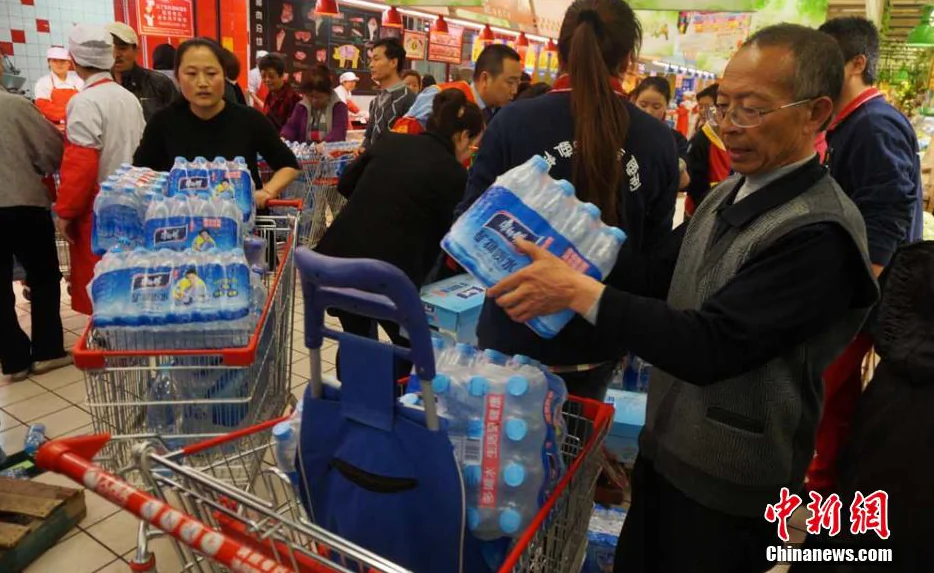 Citizens carry bottled water out of a supermarket in Lanzhou, northwest China's Gansu Province, on April 11, 2014, after tap water in a Lanzhou was found to contain excessive levels of the toxic chemical benzene. (STR/AFP/Getty Images)
