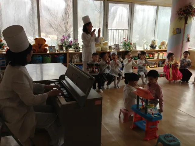 Children play at a daycare center in Pyongyang, where despite widespread poverty and a deeply militarized economy, many children enjoy better healthcare and childcare than children in wealthier Asian countries. But without a peace treaty to end the Korean War, the peninsula remains plagued by militarization and underdevelopment. (Christine Ahn)