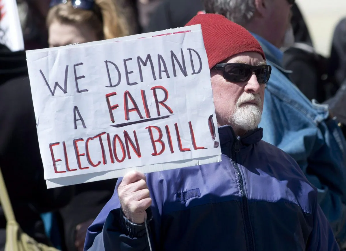 Protesters rally outside a venue where Minister of State (Democratic Reform) Pierre Poilievre was speaking about the Fair Elections Act on April 24, 2014, in Ottawa. The NDP says the Conservatives haven't allowed enough time for a clause-by-clause debate of controversial Bill C-23. (The Canadian Press/Adrian Wyld)