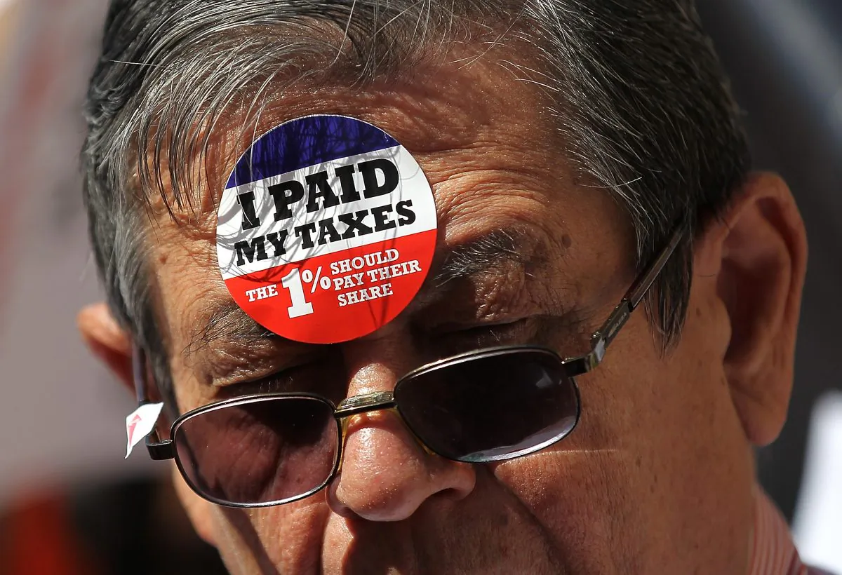 A protester wears stickers on his face during a tax day demonstration in front of the James A. Farley Post Office in New York on April 17, 2012. (Justin Sullivan/Getty Images)