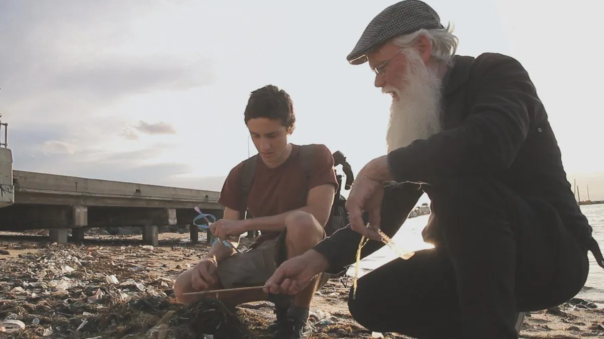 A still from Michael Lutman's documentary 'Baykeepers', showing Gio Fitzpatrick of the St Kilda EcoCentre and Neil Blake of the Port Phillip EcoCentre examining plastic litter on St Kilda Beach, in Melbourne, Australia. (Michael J. Lutman)