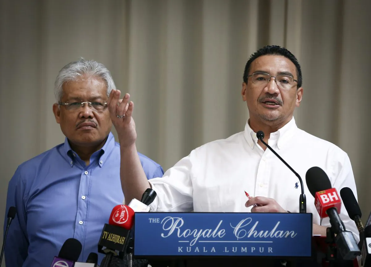 Malaysian Deputy Minister of Foreign Affairs Hamzah Zainudin, left, listens as Malaysia's acting Transport Minister Hishammuddin Hussein answers a question from a journalist during a press conference on the missing Malaysia Airlines Flight 370 at a hotel in Kuala Lumpur, Malaysia, April 19, 2014. AP Photo/Vincent Thian)