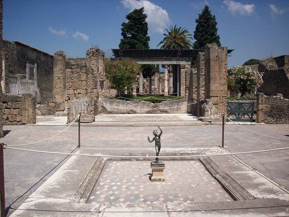A copy of the Dancing Faun, photographed in 2008, placed in the center of the impluvium at the House of the Faun, Pompeii. The original sculpture would have been placed at the lip of the pool. (Porsche997SBS/Wikimedia Commons)
