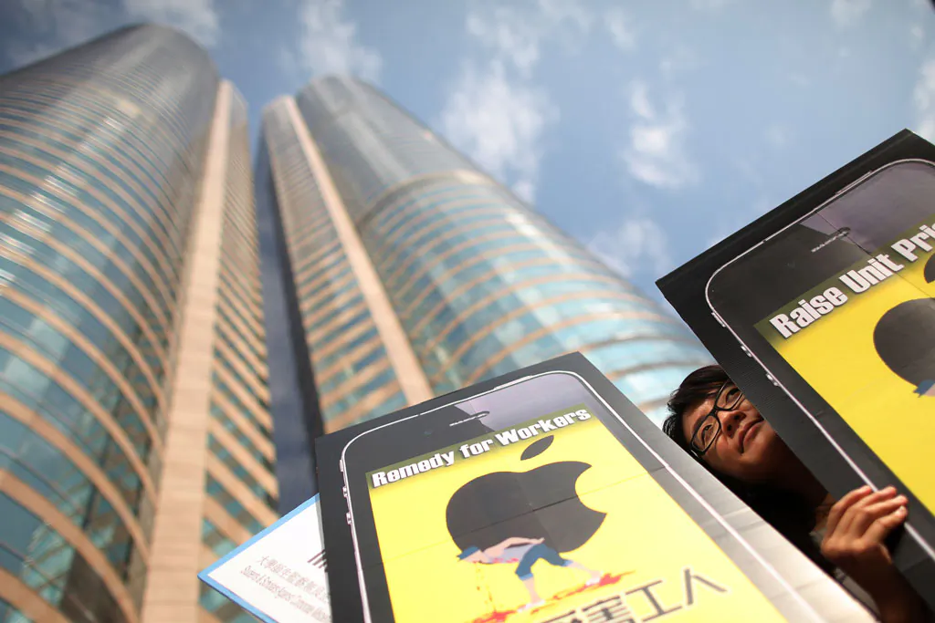 A woman holds a banner outside the Hong Kong stock exchange on October 15, 2011, calling for better conditions for factory workers making Apple products during a protest. (Ed Jones/AFP/Getty Images)