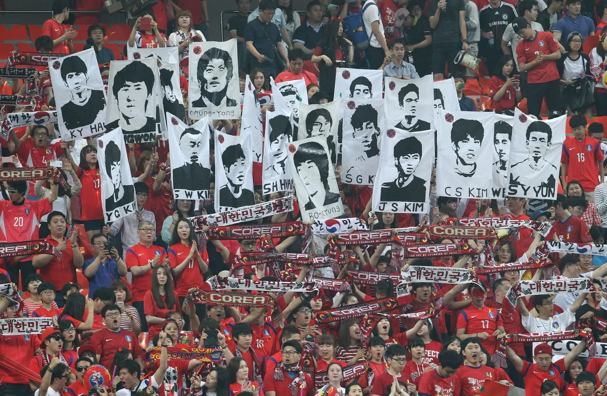 Soccer fans hold up portraits of South Korean national soccer team players before a friendly soccer match between South Korea and Tunisia at World Cup stadium in Seoul, South Korea, Wednesday, May 28, 2014. South Korea will play against Belgium, Russia and Algeria in Group H of the World Cup 2014 in Brazil. (AP Photo/Ahn Young-joon)