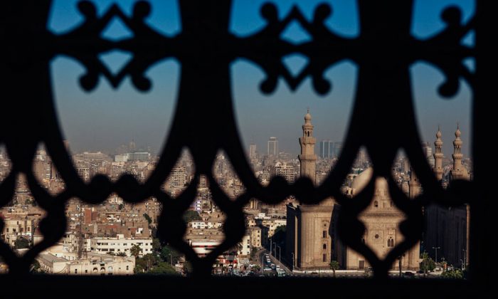 The city skyline of Cairo is seen through a window of the Muhammad Ali Mosque in Cairo's Citadel on October 21, 2013 in Cairo, Egypt. The Muhammad Ali Mosque, completed in the 1850's, is one of Cairo's major tourist attractions. After a summer of violence, tourist numbers across Egypt are at their lowest levels since a 2010 peak in tourism in the country. While Egypt's tourism sector took a dive following the popular uprising that overthrew President Hosni Mubarak in early 2011, occupancy rates of hotels in the capital Cairo and across Egypt have been reported as dramatically down since the Egyptian military's overthrow of President Morsi in July. In 2010, tourism represented 13 percent of Egypt's economy and employed one in seven of the country's workers. (Ed Giles/Getty Images)
