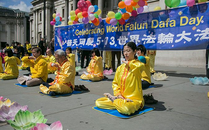 Falun Dafa practitioners do the discipline's sitting meditation in London's Trafalgar Square on May 10, 2014, in celebration of World Falun Dafa Day. (Luo Yuan/Epoch Times)