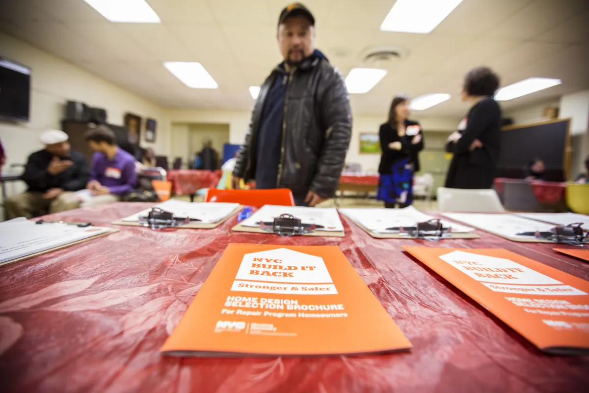 A man looks at a flier at a New York City Build It Back community meeting in Coney Island, Brooklyn, New York, on Feb. 18, 2014. (Edward Dai/Epoch Times)