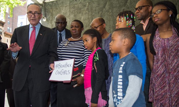 Sen. Charles Schumer holds a sign with children of Nigerian immigrants at a press conference outside the Nigerian consulate in New York on May 11, 2014. The sign references the 276 Nigerian girls who were kidnapped in Nigeria by Boko Haram, an Islamic militant group. (Ivan Pentchoukov/Epoch Times)