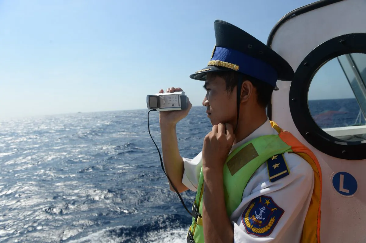 This picture taken on May 14, 2014 shows a Vietnamese coast guard officer taking pictures of a Chinese coast guard vessel near China's oil drilling rig in disputed waters in the South China Sea. (Hoang Dinh Nam/AFP/Getty Images)