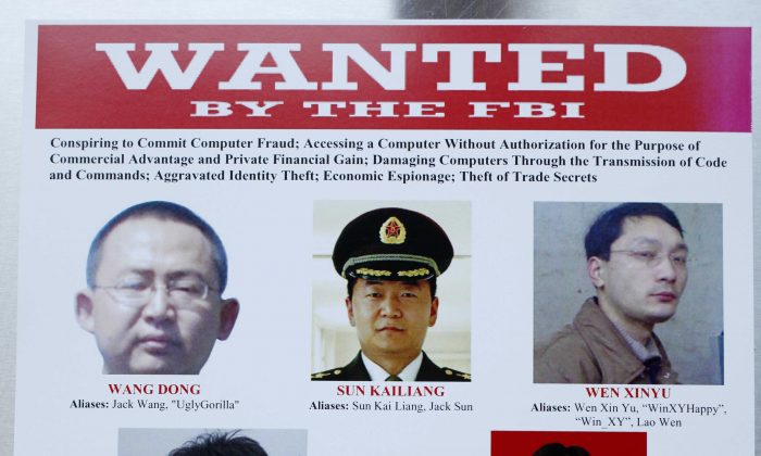 This wanted poster is displayed at the Justice Department in Washington, Monday, on May 19, 2014, after Attorney General Eric Holder, and other security executives held a news conference where Holder announced that a U.S. grand jury has charged five Chinese hackers with economic espionage and trade secret theft, the first-of-its-kind criminal charges against Chinese military officials in an international cyber-espionage case. (AP Photo)