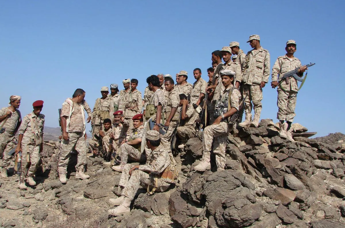 In this handout photo provided by Yemen's Defense Ministry, Yemeni troops take position during the fight against al-Qaida militants in the southern province of Shabwa, Yemen, Wednesday, April 30, 2014. Yemeni military on Tuesday, April 29, launched a major offensive targeting al-Qaida hideouts and strongholds, killing at least eight suspected militants, security officials said. (AP Photo/Yemen's Defense Ministry)