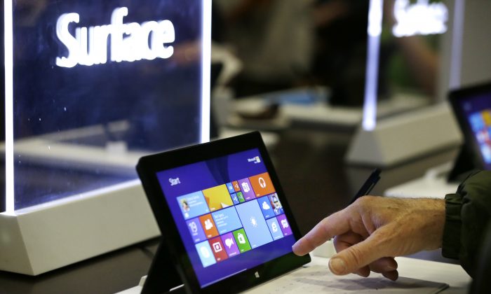 Microsoft shareholders look over Surface tablets on display before the annual shareholder meeting Tuesday, Nov. 19, 2013, in Bellevue, Wash. (AP Photo/Elaine Thompson)