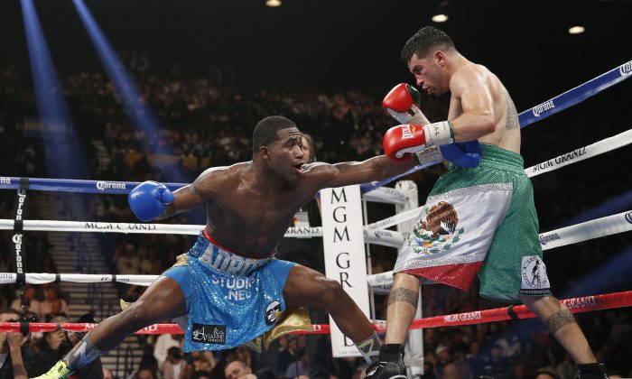 Adrien Broner, left, from Cincinnati, Ohio, throws a left to the body of Carlos Molina, from Norwalk, Calif., in their WBA super lightweight title boxing fight Saturday, May 3, 2014, in Las Vegas. (AP Photo/Eric Jamison)