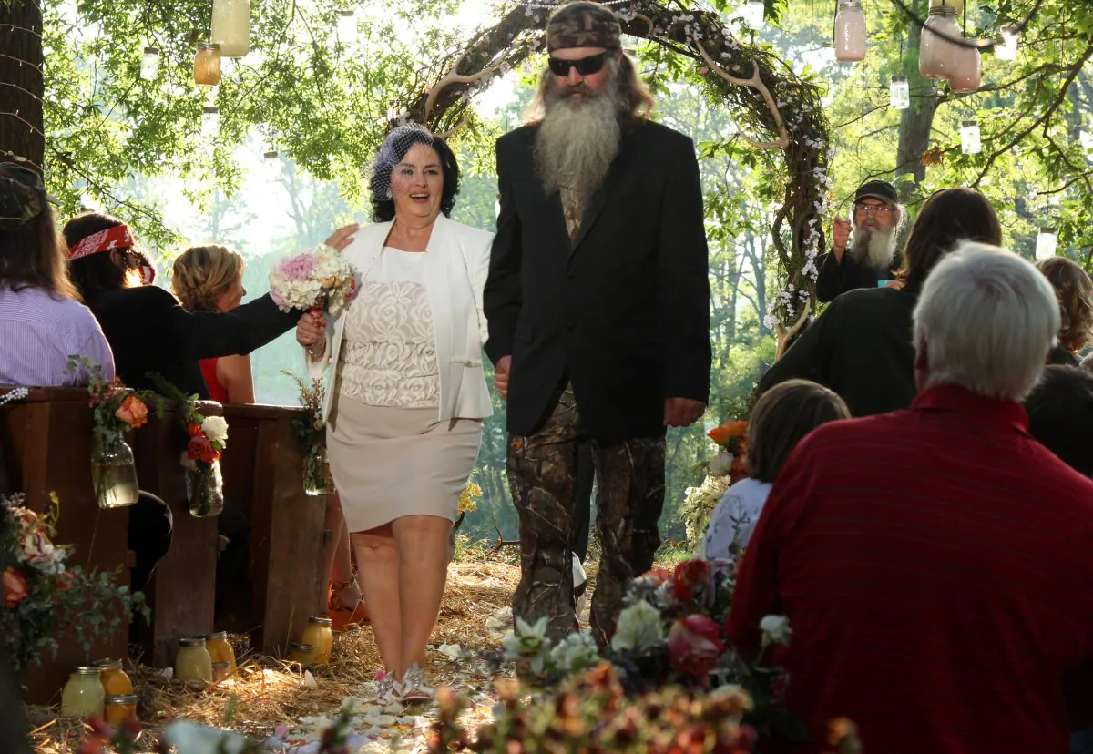 This publicity image released by A&E shows Miss Kay Robertson, left, and Phil Robertson renewing their vows in a scene from the the season 4 premiere of "Duck Dynasty."  A&E says nearly 12 million birds of a feather caught the season premiere of the hit unscripted series on Wednesday, Aug. 14, 2013. (AP Photo/A&E)
