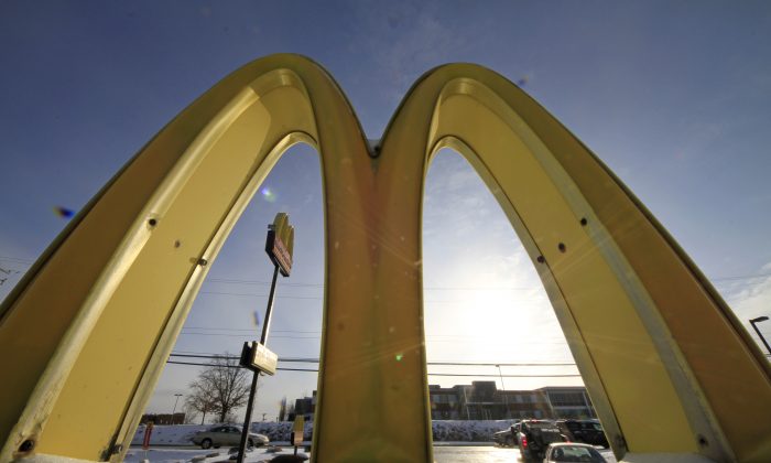 In this Tuesday, Jan. 21, 2014, photo, cars drive past the McDonald's Golden Arches logo at a McDonald's restaurant in Robinson Township, Pa.  (AP Photo/Gene J. Puskar)