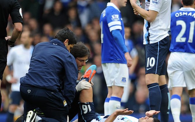 Manchester City's Sergio Aguero receives treatment on the pitch during their English Premier League soccer match against Everton at Goodison Park in Liverpool, England, Saturday May 3, 2014. (AP Photo/Clint Hughes)