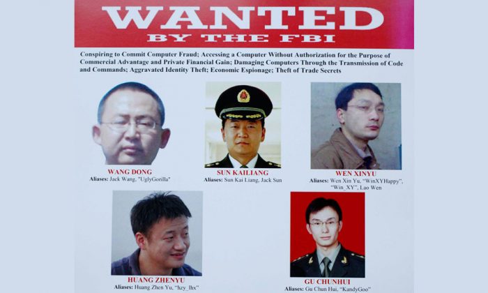 The five Chinese hackers that a U.S. grand jury has charged, are displayed on posters in Washington, on May 19, 2014. (AP Photo/Charles Dharapak)
