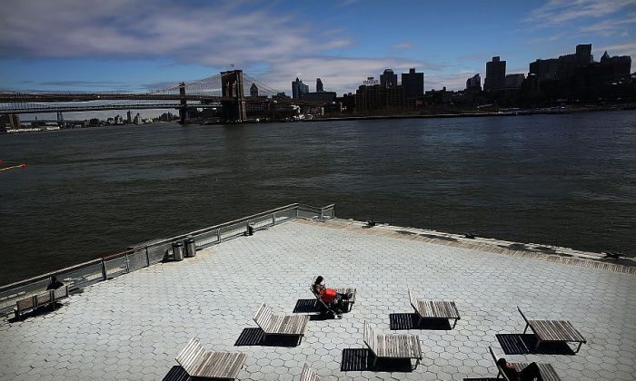 A person sunbathes at South Street Seaport—an area of lower Manhattan that was severely flooded during Hurricane Sandy—in New York on March 31, 2014. (Spencer Platt/Getty Images) 