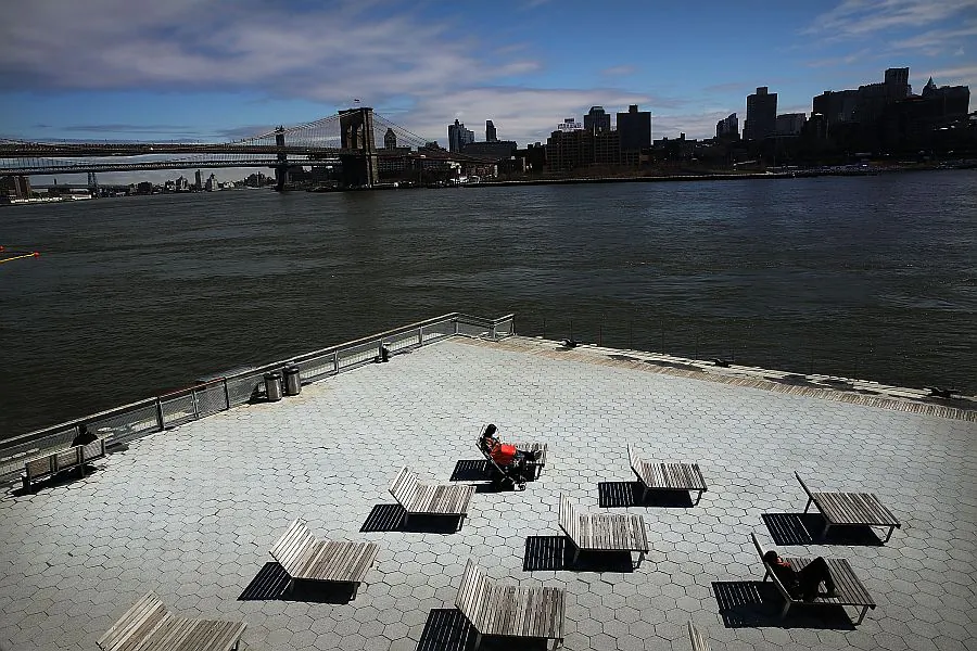 A person sunbathes at South Street Seaport—an area of lower Manhattan that was severely flooded during Hurricane Sandy—in New York on March 31, 2014. (Spencer Platt/Getty Images) 
