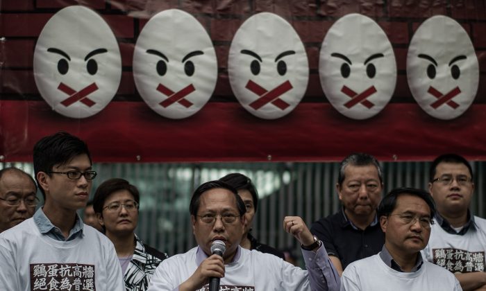 Protesters stand under a banner as they prepare to go on a hunger strike to call for “true” –––universal suffrage in Hong Kong on March 28, 2014. Around 15 pan-democrats, including five of the city’s lawmakers, took part in the hunger strike, a step-up action as fears that intervention by China could prevent genuine political reform increased. (Philippe Lopez/AFP/Getty Images)