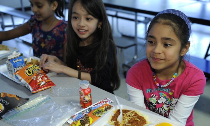 (L–R) Ruth Gebregiorgis, 8, Amina Sharif, 7, and Brianna Delcid-Gomez, 7, eat lunch at the Patrick Henry Elementary School in Alexandria, Va., April 29. (AP Photo/Susan Walsh)