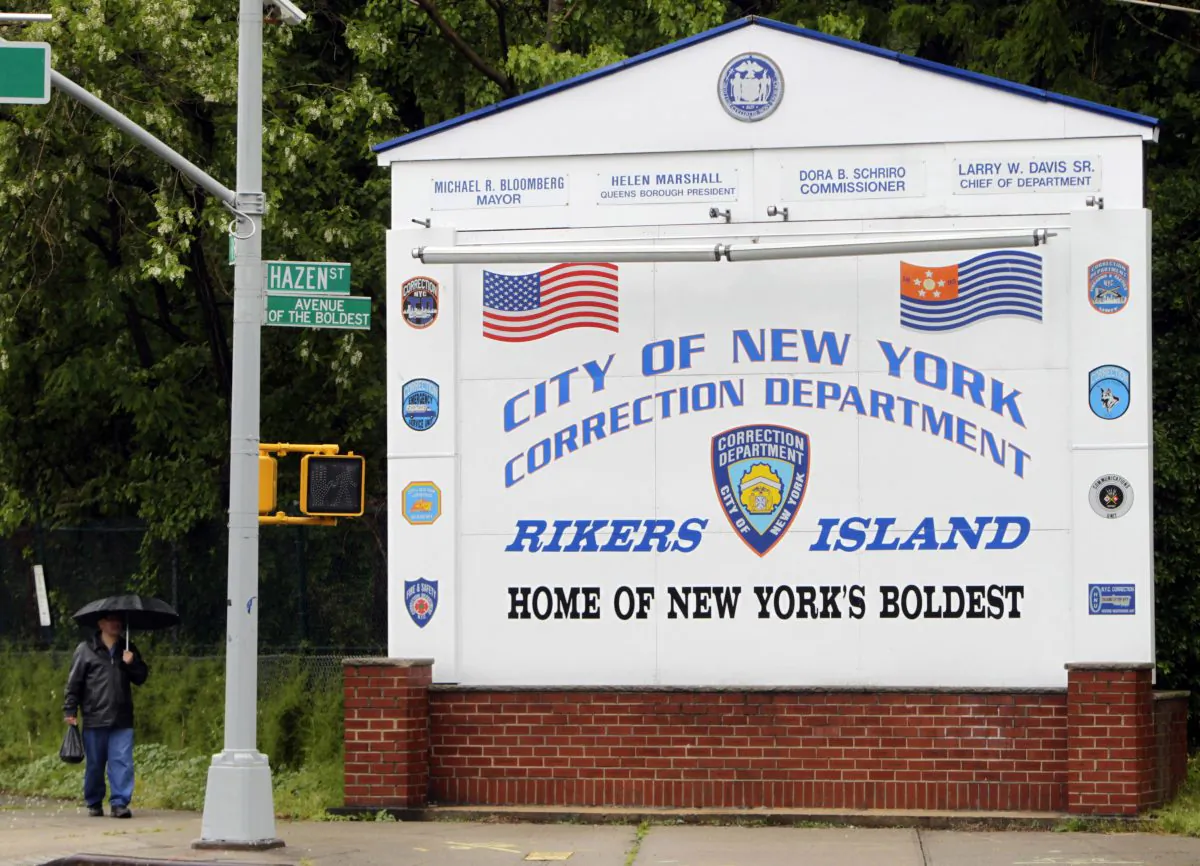 In this May 17, 2011, file photo, a man walks near the sign at the entrance to the Rikers Island jail in New York. (AP Photo/Seth Wenig, File)