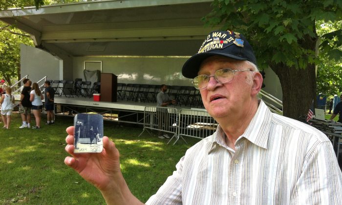 Veteran Jack Vanasco shows a picture of himself next to General Douglas MacArthur during World War II. (Sarah Le/Epoch Times)