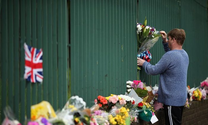 Members of the community lay flowers in London on May 24, 2013. The pictured location is near Woolwich Army Barracks and is the scene where Drummer Lee Rigby of the 2nd Battalion the Royal Regiment of Fusiliers was killed by suspected Islamists. (Dan Kitwood/Getty Images)