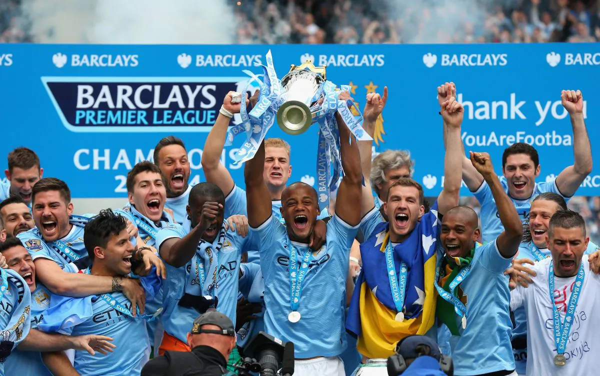 Vincent Kompany of Manchester City lifts the Premier League trophy in celebration along with his teammates at the Etihad Stadium on May 11, 2014 in Manchester, England. (Alex Livesey/Getty Images)