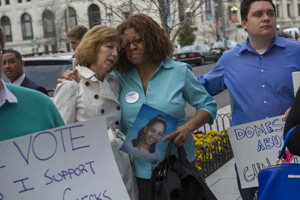 Nardyne Jefferies (C) of Washington DC, whose 16-year-old daughter Brishell Jones was shot and killed on March 30, 2010, is comforted by Lori Hass (L), whose daughter was shot and injured in the 2007 Virginia Tech massacre, and Christian Heyne (R) of Thousand Oaks, California, whose parents were shot (and his mother killed) in Thousand Oaks, during a gun control rally outside the National Shooting Sports Foundation's annual Congressional Fly-In fundraising dinner in Washington, D.C., on April 2, 2014. (Rod Lamkey/Getty Images)