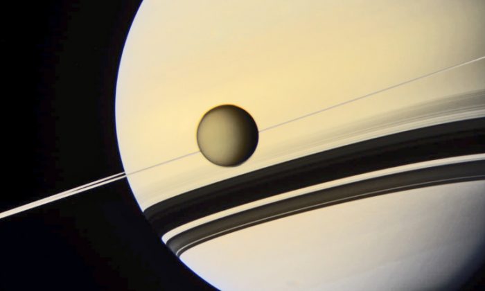 Like a tethered child, Titan accompanies Saturn in orbit. The ringed planet’s own 29.5-year orbit around the Sun is slightly eccentric, as summer in Titan’s southern hemisphere occurs when Saturn (and Titan) are closest to the Sun. This makes southern summer warmer and faster, when compared to northern ones. (NASA/JPL/SSI/color composite by Val Klavans)