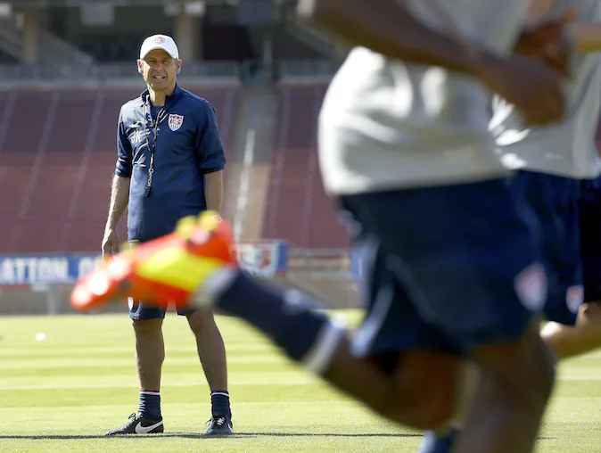 U.S. men's soccer coach Jurgen Klinsmann watches players warm up during a training session Wednesday, May 14, 2014, in Stanford, Calif. The team began a two-week training camp leading up to a May 27 exhibition with Azerbaijan at San Francisco's Candlestick Park. (AP Photo/Tony Avelar)