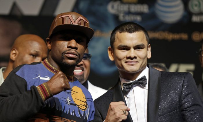 Floyd Mayweather Jr., left, and Marcos Maidana pose for photos during a news conference Wednesday, April 30, 2014, in Las Vegas. The pair square off in a welterweight title fight on Saturday, May 3.  (AP Photo/Isaac Brekken)