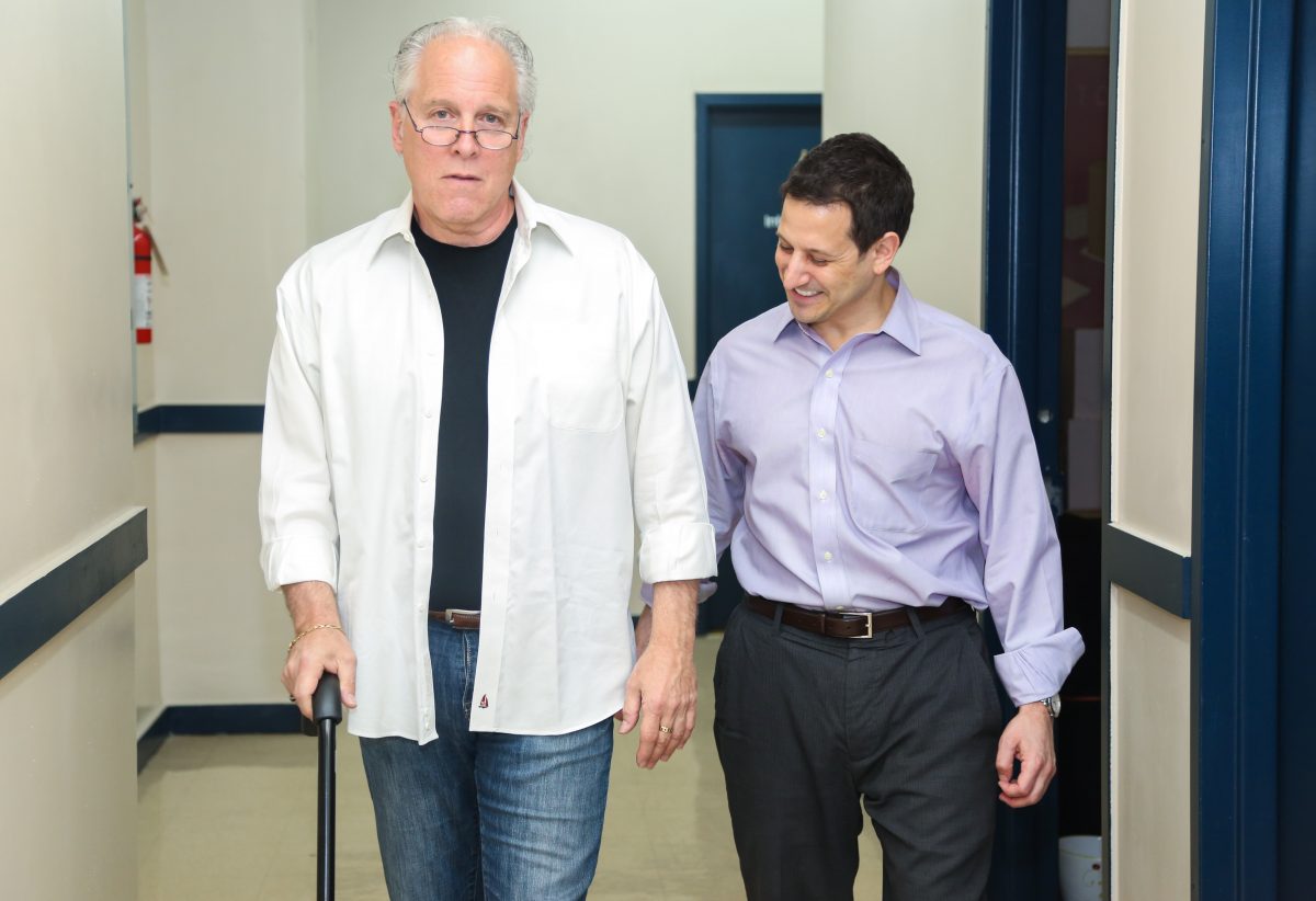 Alex Greenspan MSPT (R) assists a patient in walking in New York City on May 7. Greenspan is the founder of Outreach Rehabilitation, which specializes in in-home physical, occupational, and speech rehabilitation therapy for older adults. (Benjamin Chasteen/Epoch Times)