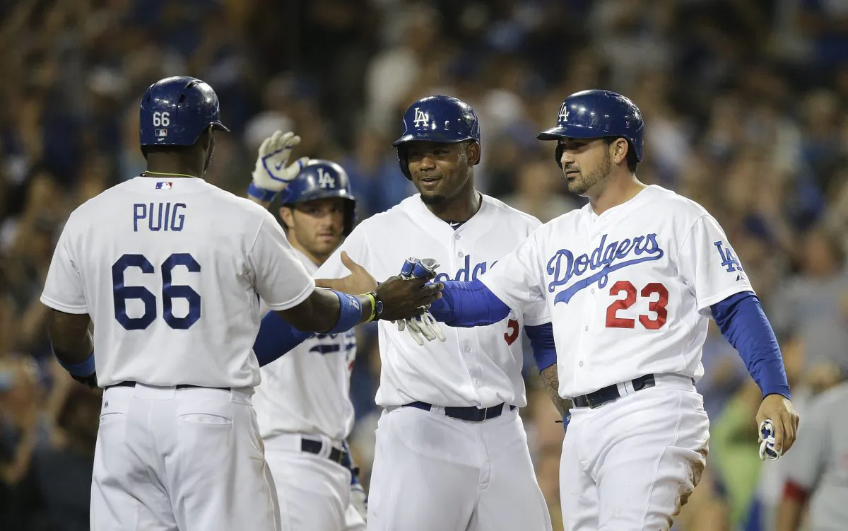 Los Angeles Dodgers' Yasiel Puig, Carl Crawford and Adrian Gonzalez, from left, celebrate after they scored on a triple hit Andre Ethier during the fourth inning of a baseball game against the Cincinnati Reds on Tuesday, May 27, 2014, in Los Angeles. (AP Photo/Jae C. Hong)