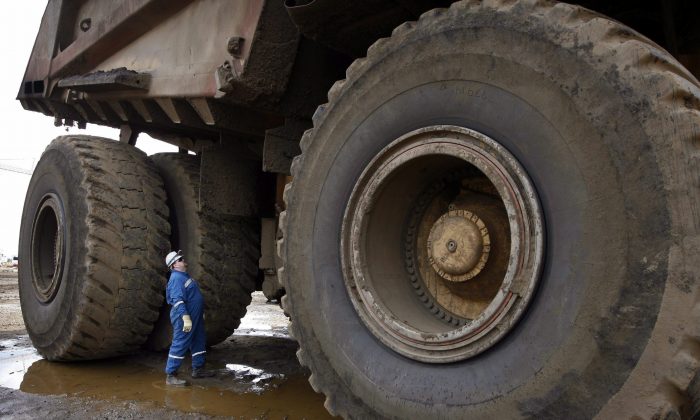 A worker inspects his haul vehicle before his shift as a driver at the Shell Albian Sands oilsands mine near Fort McMurray on July 9, 2008. The demands of working in Alberta's oilsands is taking its toll on workers' marriages, says relationship expert Debra Macleod. (The Canadian Press/Jeff McIntosh)
