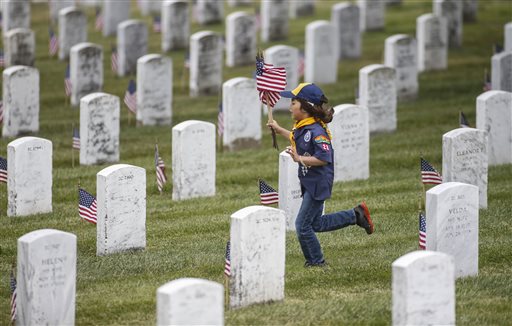 Cub Scout Mateo Armijo, 7, with Pack 28 in Burlingame, runs with flags at the Golden Gate National Cemetery in San Bruno, Calif., on Saturday, May 24, 2014.  Thousands of Boy Scouts, Cub Scouts, and Girl Scouts took part in the annual event to place 117,000 tiny flags on the graves. (AP Photo/The Tribune, John Green)