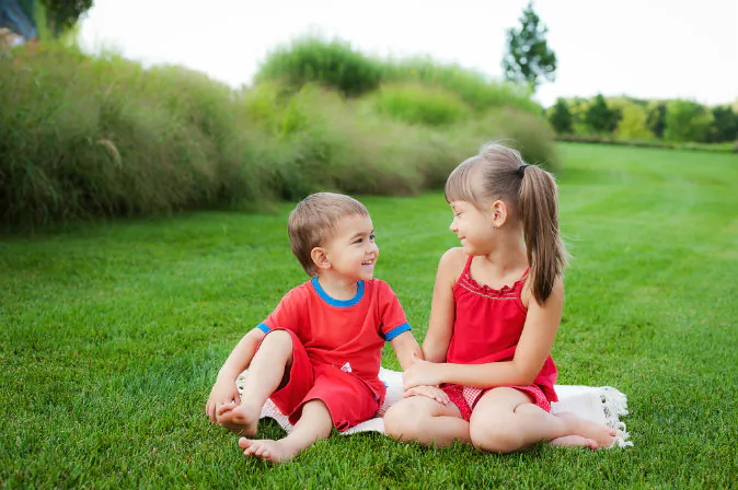 * Children enjoy sitting on a lawn together