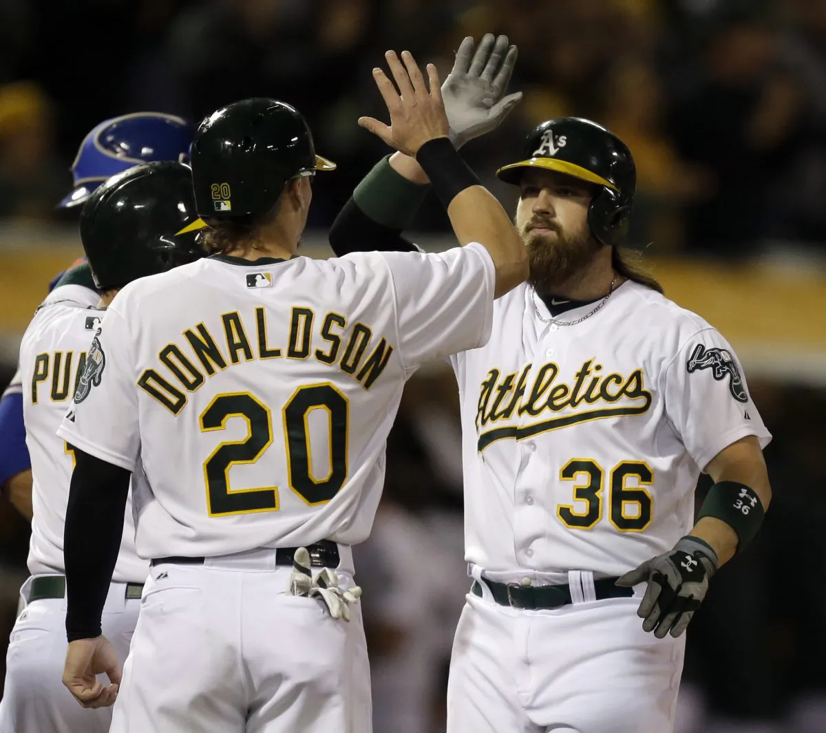 Oakland Athletics' Josh Donaldson, left, congratulates Derek Norris, right, after Norris hit a three-run home run off off Texas Rangers' Shawn Tolleson in the sixth inning of a baseball game Tuesday, June 17, 2014, in Oakland, Calif. (AP Photo/Ben Margot)