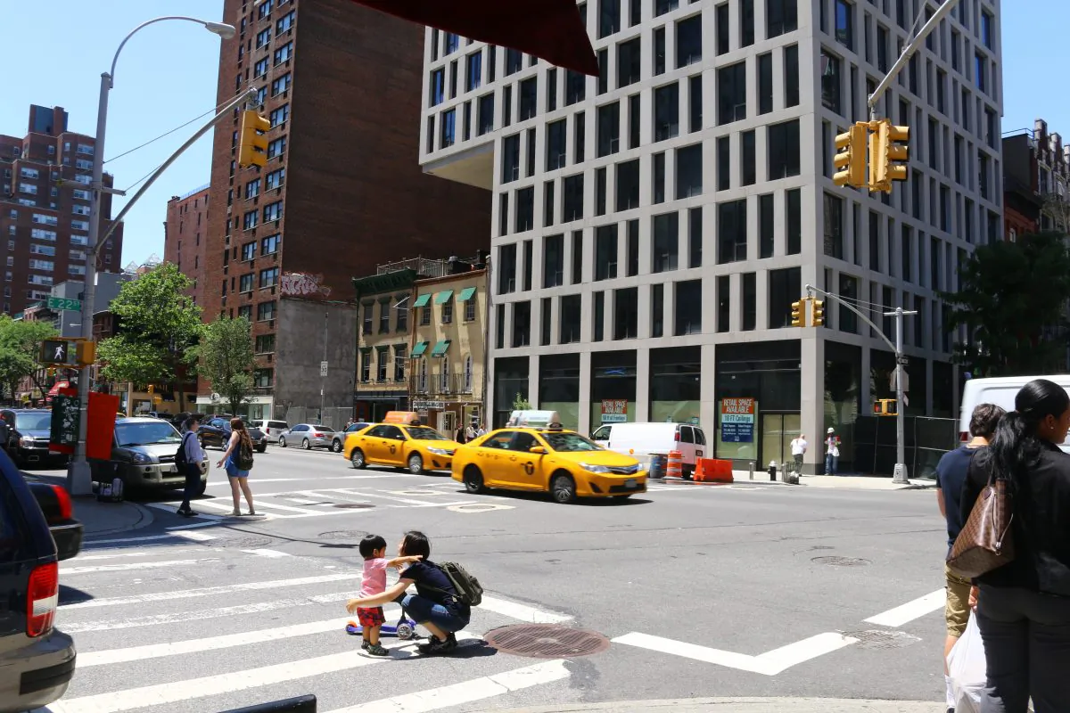 Mother and child cross the dangerous 3rd Avenue and East 22nd Street intersection, New York, June 16, 2014. (Brendon Fallon/Epoch Times)