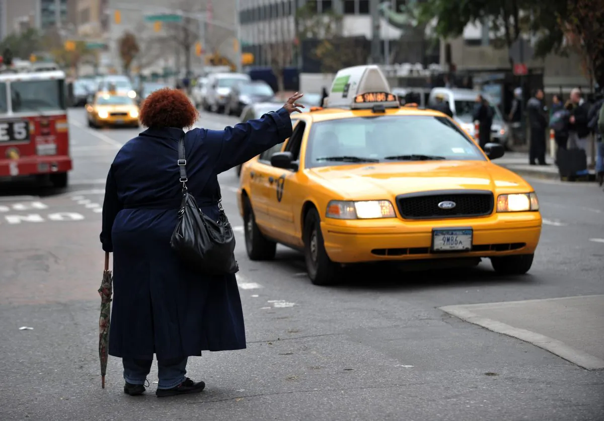 A woman tries to hail a taxi on First Avenue October 31, 2012 in New York. (Stan Honda/AFP/Getty Images)