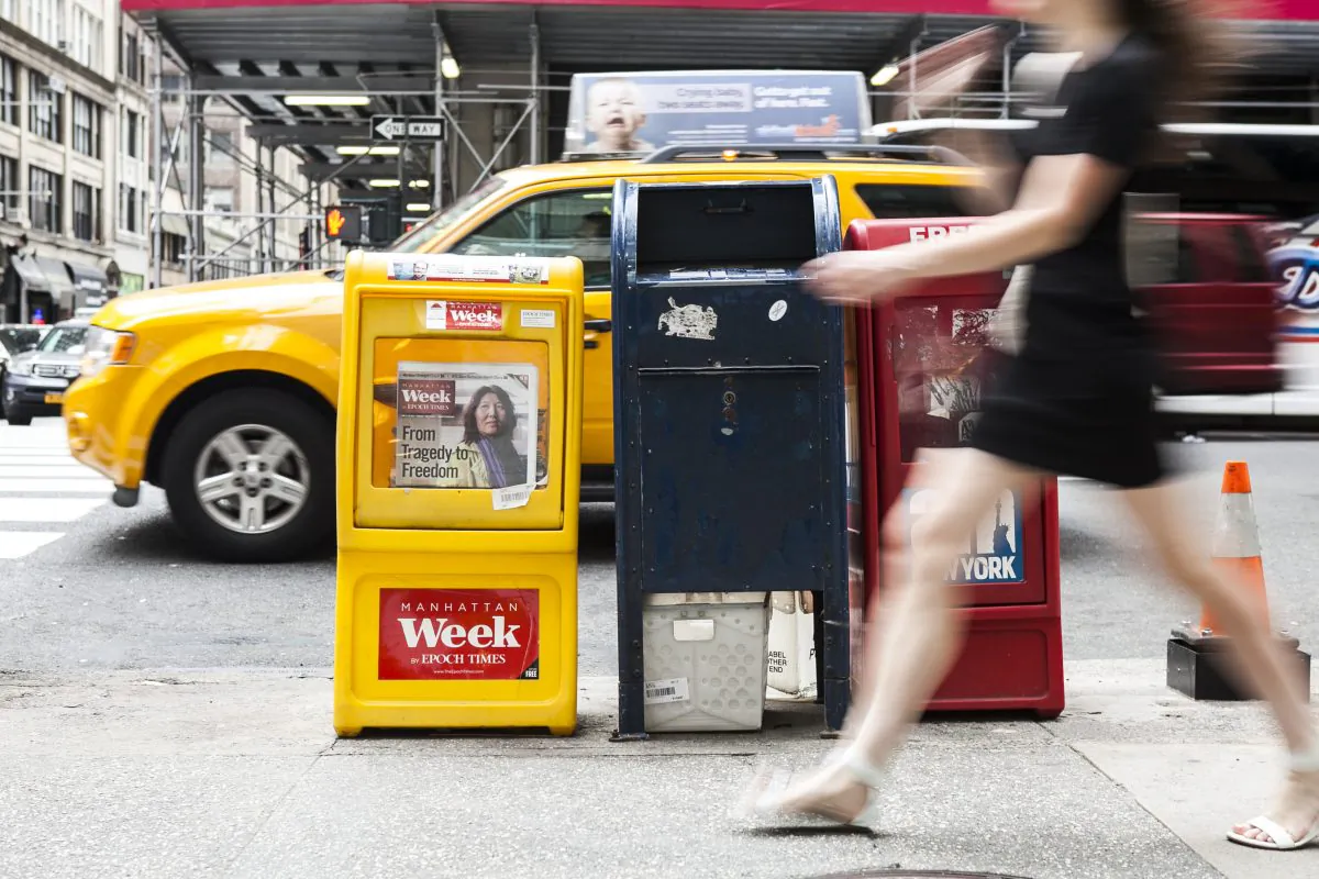 A passerby walks past an Epoch Times box on the streets of Manhattan, on May 19, 2014. Former Congressman Lee Hamilton argues that a vigorous, independent press is necessary for the good health of U.S. democracy. (Samira Bouaou/Epoch Times)