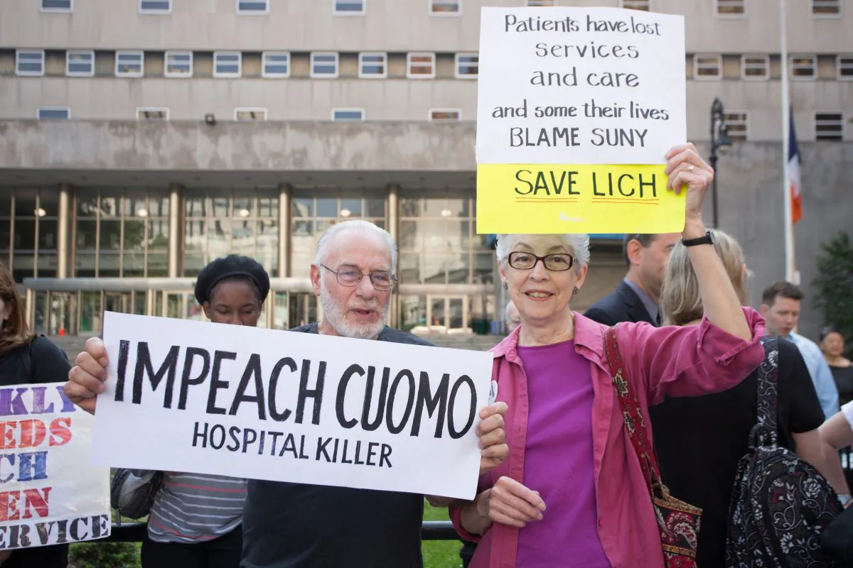 Bob and Brenda Pepper hold signs during a rally to save the Long Island College Hospital from being shut down at the King County Superior Court in the Brooklyn borough of New York City on June 3, 2014. (Laura Cooksey/Epoch Times)