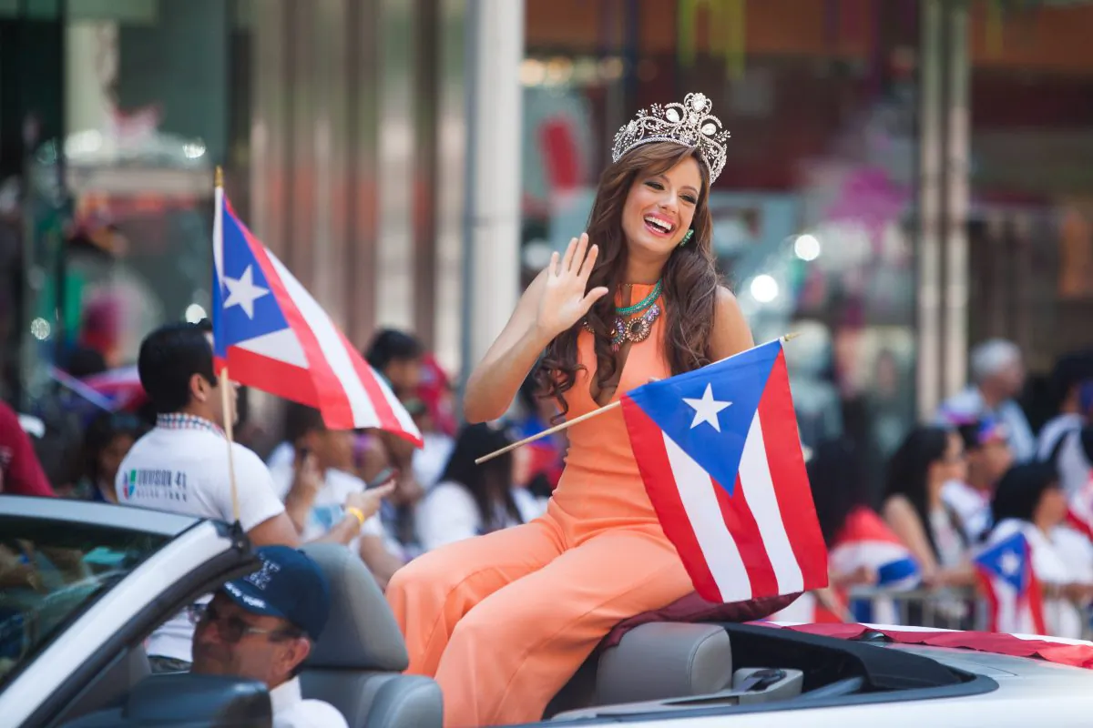 A women waves to onlookers at the National Puerto Rican Day Parade in Manhattan, on Sunday. (Petr Svab/Epoch Times)