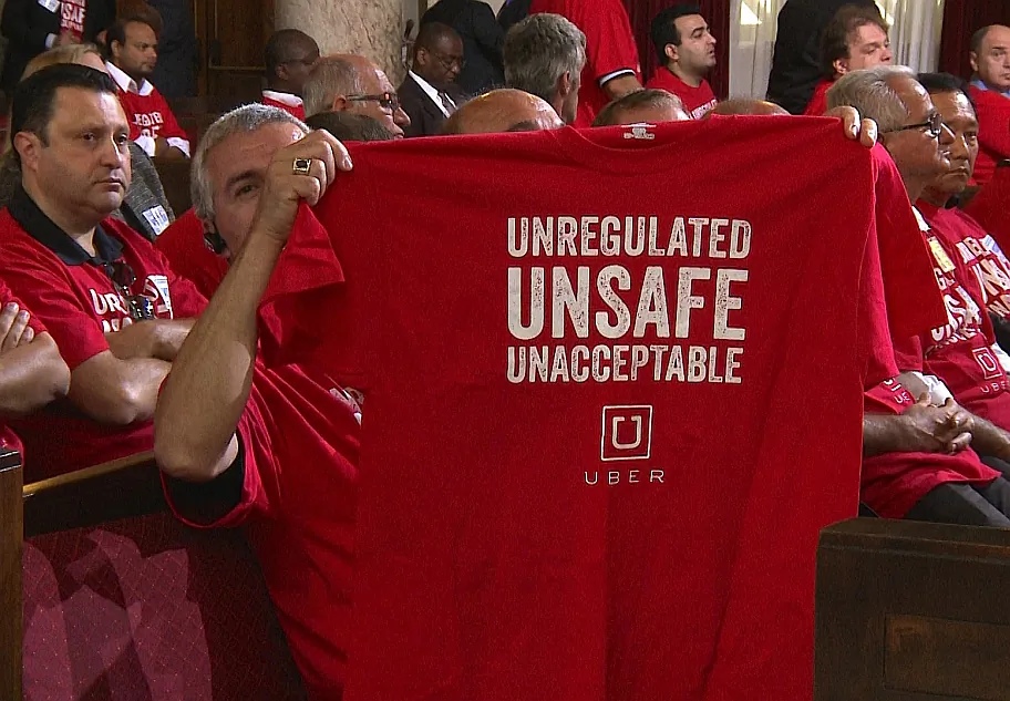 A protester shows a shirt at LA City Council on Tuesday. (Erich Zhang/NTD) 